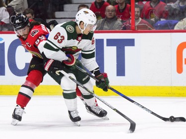 Minnesota Wild's Tyler Ennis, right, works to keep the puck away from Ottawa Senators' Erik Karlsson during first period NHL hockey action in Ottawa on Tuesday, Dec. 19, 2017.