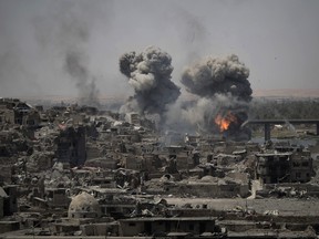 In this July 11, 2017 file photo, airstrikes target Islamic State positions on the edge of the Old City in Mosul, Iraq. Iraq said Saturday, Dec. 9, 2017 that its war on the Islamic State is over.