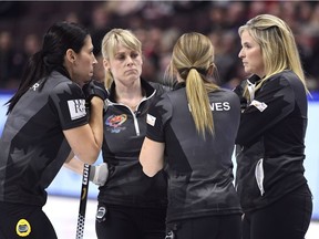 Jennifer Jones, right, Jill Officer, Dawn McEwen and Kaitlyn Lawes talk at the end of the eighth end before deciding to concede the final round-robin game against Rachel Homan's Ottawa team in the Olympic curling trials at Canadian Tire Centre.