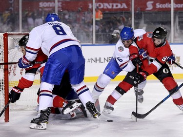 Matt Duchene (R) tries to put the puck in the net with Shea Weber on his back while Jordie Benn checks Mike Hoffman into the net in the first period as the Ottawa Senators take on the Montreal Canadiens in the 2017 Scotiabank NHL 100 Classic outdoor hockey game at TD Place in Ottawa.  Photo by Wayne Cuddington/ Postmedia
