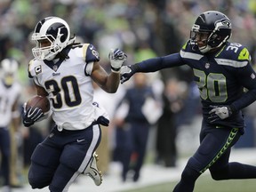 Los Angeles Rams running back Todd Gurley, left, rushes past Seattle Seahawks defensive back Bradley McDougald, right, during the first half of an NFL football game, Sunday, Dec. 17, 2017, in Seattle.