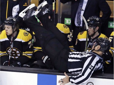 Linesman Tony Sericolo (84) goes over the boards into the Bruins bench during the third period of Wednesday's game against the Senators.