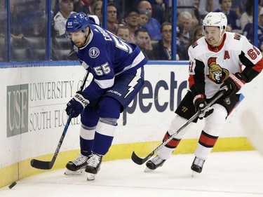 Tampa Bay Lightning defenseman Braydon Coburn (55) moves the puck ahead of Ottawa Senators right wing Mark Stone (61) during the first period of an NHL hockey game Thursday, Dec. 21, 2017, in Tampa, Fla.