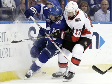 Ottawa Senators center Nate Thompson (17) checks Tampa Bay Lightning left wing Chris Kunitz (14) into the boards as they chase a loose puck during the first period of an NHL hockey game Thursday, Dec. 21, 2017, in Tampa, Fla.