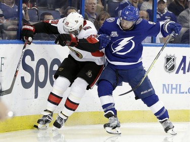 Ottawa Senators defenseman Johnny Oduya (29) and Tampa Bay Lightning center Tyler Johnson (9) battle for the puck during the second period of an NHL hockey game Thursday, Dec. 21, 2017, in Tampa, Fla.