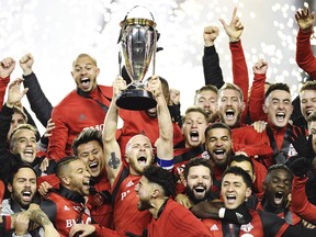 Toronto FC midfielder Michael Bradley raises the trophy as Toronto FC celebrates their victory over the Seattle Sounders in MLS Cup Final soccer action in Toronto on Saturday.