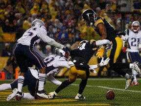 Antonio Brown of the Pittsburgh Steelers (right) lands awkwardly after being unable to catch a pass in the second quarter during his team’s game against the New England Patriots at Heinz Field. Brown reportedly has a partially torn calf muscle. (JUSTIN K. ALLER/Getty Images)