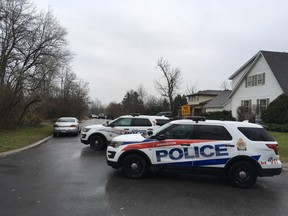 Kingston Plice vehicles block access to Graceland Avenue in Kingston, Ont. on Tuesday, Dec. 5, 2017. Police were called to the area after reports of a man with a gun inside. When police entered they found an elderly woman dead and the elderly man with critical injuries. Elliot Ferguson/The Whig-Standard/Postmedia Network