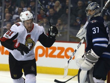 Ottawa Senators forward Mark Stone gets after the puck in front of Winnipeg Jets goaltender Connor Hellebuyck in Winnipeg on Sun., Dec. 3, 2017. Kevin King/Winnipeg Sun/Postmedia Network ORG XMIT: POS1712031909307686