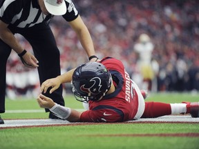 In this file photo, Houston Texans quarterback Tom Savage is checked by a referee after he was hit during the first half of an NFL football game against the San Francisco 49ers. Savage left the game and it was later determined he had a concussion.
