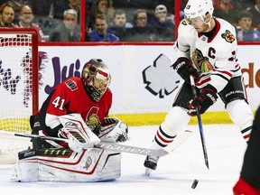 Senators goaltender Craig Anderson makes this save during Tuesday's game with Blackhawks captain Jonathan Toews standing nearby, but also allowed four goals before being replaced by Mike Condon. Errol McGihon/Postmedia