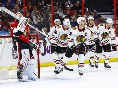 Ottawa Senators Craig Anderson adjust his mask as Chicago Blackhawks Jonathan Toews leads his team back to the bench after celebrating a second period goal during NHL action at the Canadian Tire Centre in Ottawa on January 9,2018. Errol McGihon/Postmedia ORG XMIT: POS1801092040307230
