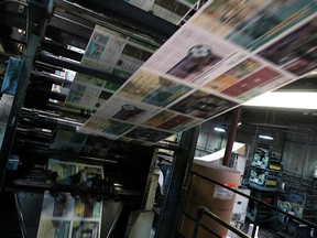 Newspapers roll through a printing  press.