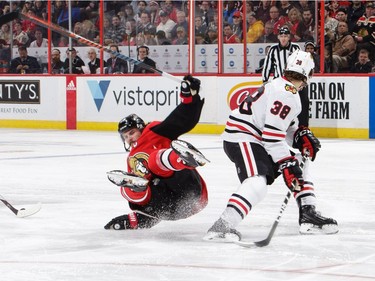 OTTAWA, ON - JANUARY 9: Erik Karlsson #65 of the Ottawa Senators falls to the ice after contact with Ryan Hartman #38 of the Chicago Blackhawks in the second period at Canadian Tire Centre on January 9, 2018 in Ottawa, Ontario, Canada.