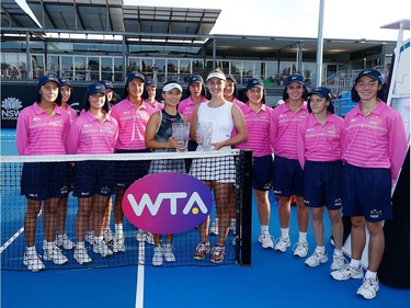 Gabriela Dabrowski of Ottawa and Yifan Xu of China pose for a photo with young ball retrievers after winning the Sydney International women's doubles final on Friday.