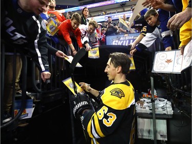 Brad Marchand of the Boston Bruins signs autographs before the skills competition in Tampa.