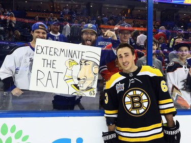 He may be serving an NHL suspension, but Brad Marchand of the Bruins finds reason to smile while posing for a photo with fans at the NHL All-Star Game skills competition in Tampa on Saturday night.