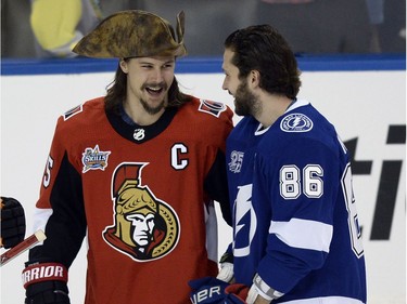 The pirate hat of Senators defenceman Erik Karlsson gets the attention of Lightning forward Nikita Kucherov.