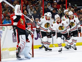 Ottawa Senators goalie Craig Anderson adjusts his mask as Chicago Blackhawks Jonathan Toews leads his team back to the bench after celebrating a goal on Jan. 9, 2018