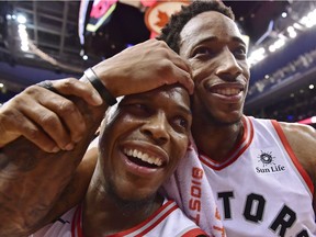 Toronto guards Kyle Lowry, left, and DeMar DeRozan celebrate after Monday's overtime victory against Milwaukee.