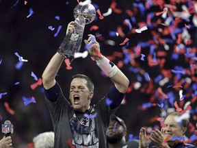 In this Feb. 5, 2017, file photo, New England Patriots' Tom Brady raises the Vince Lombardi Trophy after defeating the Atlanta Falcons in overtime at the NFL Super Bowl 51 football game, in Houston. Six months ahead of the next Super Bowl, Bell Media is re-launching a fight over the CRTC's decision to ban substituting big-budget American ads with Canadian ones during the big game. THE CANADIAN PRESS/AP/Darron Cummings ORG XMIT: CPT120