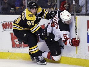 Bruins winger Brad Marchand checks Devils defenceman Will Butcher into the boards during the second period of Tuesday's game. The five-game suspension levied by the NHL was for an elbow to the head of the Devils' Marcus Johansson in the same game.