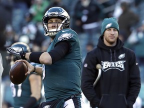 In this Jan. 13, 2018, file photo, Philadelphia Eagles' Nick Foles, left, warms up as Carson Wentz looks on before an NFL divisional playoff football game against the Atlanta Falcons,in Philadelphia. (AP Photo/Michael Perez, File)