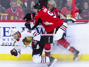 Chicago Blackhawks' Ryan Hartman (38) gets pushed to the ice by Ottawa Senators' Bobby Ryan during the first period of NHL hockey action in Ottawa on Tuesday, Jan. 9, 2018.