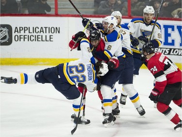 The Senators' Gabriel Dumont gets tangled up with the Blues' Chris Thorburn with Ottawa teammate Mark Borowiecki closing in.