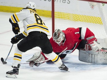 Boston Bruins right-winger David Pastrnak (88) tries to stickhandle the puck around Ottawa Senators goaltender Mike Condon.