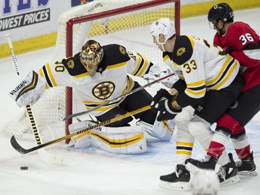Boston Bruins defenceman Zdeno Chara (33) ties up Ottawa Senators centre Colin White (36) as Bruins goaltender Tuukka Rask clears the puck.
