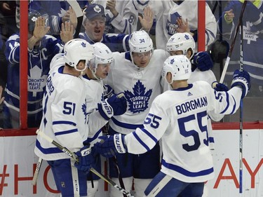 Toronto Maple Leafs fans look on as Leafs players, from left, Jake Gardiner, Zach Hyman, Auston Matthews, Andreas Borgman and William Nylander celebrate a goal by Matthews.
