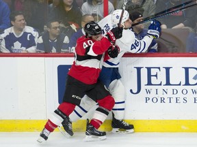Ottawa Senators centre Gabriel Dumont sends Toronto Maple Leafs defenceman Roman Polak into the boards during the first period of Saturday's game.