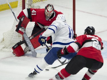 Toronto Maple Leafs centre Zach Hyman tries to put the puck past Ottawa Senators goaltender Craig Anderson as he is pressured by defenceman Dion Phaneuf.
