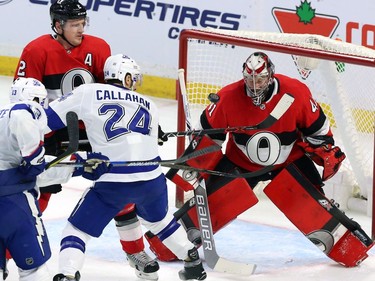 Ottawa Senators goaltender Craig Anderson (41) reacts to a flying puck as defenceman Dion Phaneuf (2) and Tampa Bay Lightning right-winger Ryan Callahan (24) look on.