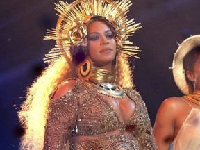 FILE - In this Feb. 12, 2017 file photo, Beyonce wears a gold, royal crown and neck collar and a Peter Dundas gown an embroidered portrait of herself as she performs at the 59th annual Grammy Awards in Los Angeles.