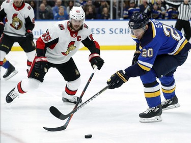 St. Louis Blues' Alexander Steen, right, and Ottawa Senators' Erik Karlsson, of Sweden, reach for the puck during the second period of an NHL hockey game Tuesday, Jan. 23, 2018, in St. Louis.