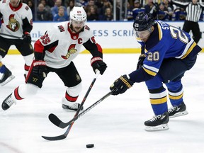 Senators captain Erik Karlsson, left, and Blues forward Alexander Steen reach for the puck during the second period Tuesday's game at St. Louis.