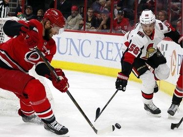Carolina Hurricanes' Jordan Staal (11) and Brett Pesce (22) take the puck away from Ottawa Senators' Magnus Paajarvi (56) during the first period of an NHL hockey game, Tuesday, Jan. 30, 2018, in Raleigh, N.C.