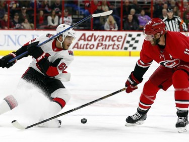Ottawa Senators' Mike Hoffman (68) has the puck poked away by Carolina Hurricanes' Jordan Staal (11) during the first period of an NHL hockey game, Tuesday, Jan. 30, 2018, in Raleigh, N.C.