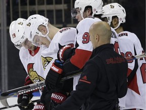 The Ottawa Senators' Mark Borowiecki, second from left, is helped off the ice after a check by the New York Rangers' Brendan Smith on Sunday, Nov. 19, 2017.