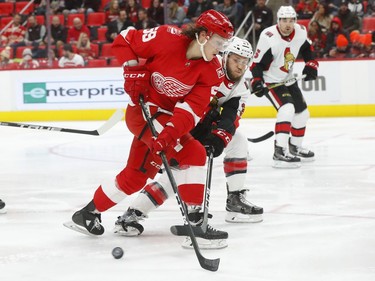 Ottawa Senators defenseman Fredrik Claesson (33) knocks the puck from Detroit Red Wings' Tyler Bertuzzi during the second period of an NHL hockey game Wednesday, Jan. 3, 2018, in Detroit.