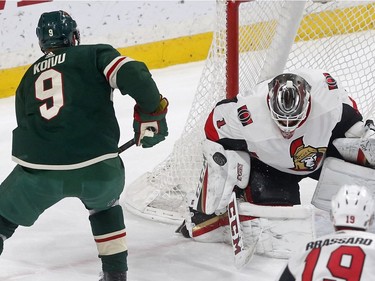 Ottawa Senators goaltender Mike Condon, right, stops a shot by Minnesota Wild's Mikko Koivu of Finland in the first period of an NHL hockey game Monday, Jan. 22, 2018, in St. Paul, Minn.