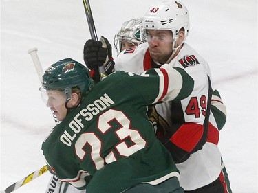 Minnesota Wild's Gustav Olofsson, left, of Sweden, wraps up Ottawa Senators' Chris Didomenico in the first period of an NHL hockey game Monday, Jan. 22, 2018, in St. Paul, Minn.