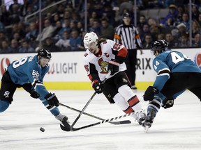 Ottawa Senators defenseman Erik Karlsson, center, is defended by San Jose Sharks center Melker Karlsson, left, and defenseman Marc-Edouard Vlasic (44) during the third period of an NHL hockey game Dec. 9, 2017.