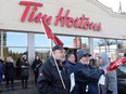 Members of Ontario Federation of Labour protest outside a Tim Hortons Franchise in Toronto on Wednesday Jan. 10, 2018. THE CANADIAN PRESS/Chris Young