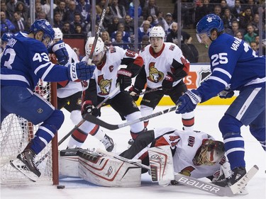 Toronto Maple Leafs left wing James van Riemsdyk (25) and Toronto Maple Leafs center Nazem Kadri (43) can't get the bouncing puck past Ottawa Senators goaltender Craig Anderson (41), as the Toronto Maple Leafs take on the Ottawa Senators at the Air Canada Centre in Toronto on Thursday January 11, 2018. Stan Behal/Toronto Sun/Postmedia Network