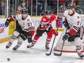 67's forward Graeme Clarke races Storm defenceman Garrett McFadden (37) and Dmitri Samorukov (5) to the puck behind the Guelph net.