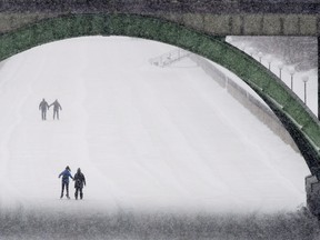 Couples skate on the Rideau Canal as milder temperatures and snow affected the region.