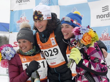 First-place Kamila Borutova, centre, second-place Karen Messenger, right, and third-place, Lena Pichard, left, celebrate at the medal ceremony for the women's 51K classic race on Saturday. Patrick Doyle/Postmedia